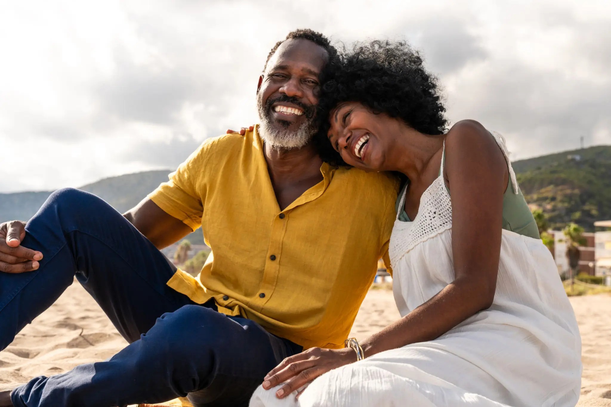 Beautiful mature black couple of lovers dating at the seaside - Married african middle-aged couple bonding and having fun outdoors, concepts about relationship, lifestyle and quality of life